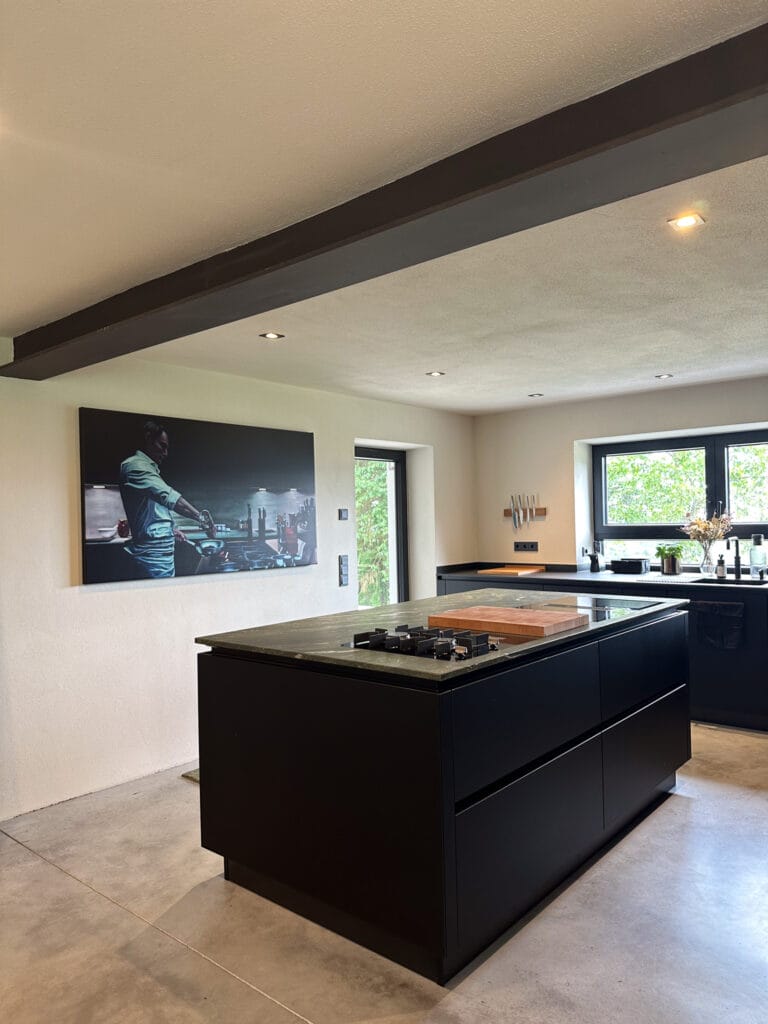 Schwarze Kochinsel in Küche mit modernem Design mit Wandbild und großem Fenster