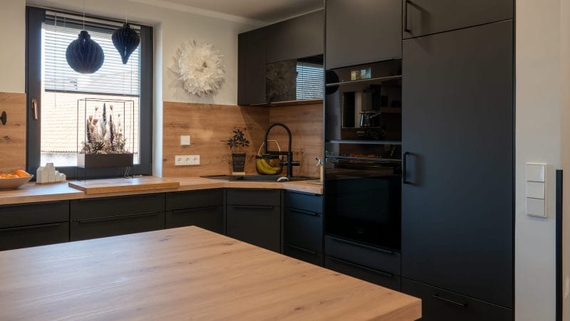 Dunkle U-Küche mit Holz-Arbeitsplatte
