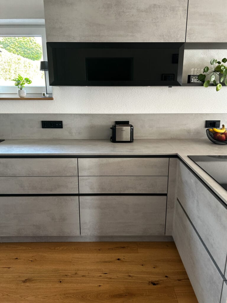 Graue L-Küche in Beton-Schubladenoptik